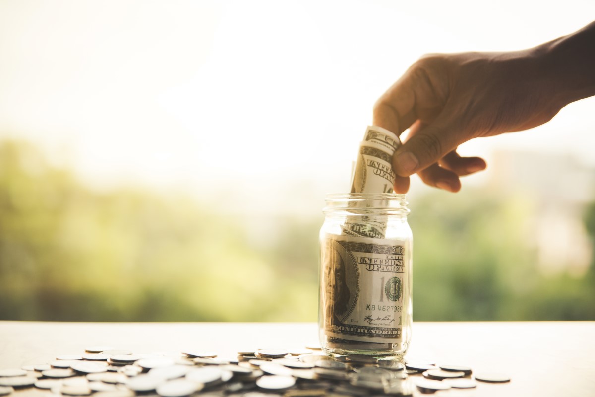 Money being put away into a Jar, symbolic of a Money Market Account