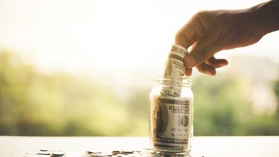 Money being put away into a Jar, symbolic of a Money Market Account